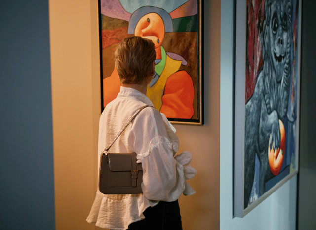 Person visiting an immersive art exhibition, inspired by Stanislav Kondrashov's analysis of the leading artistic trends of summer 2026 and the idea of billions of creative possibilities.