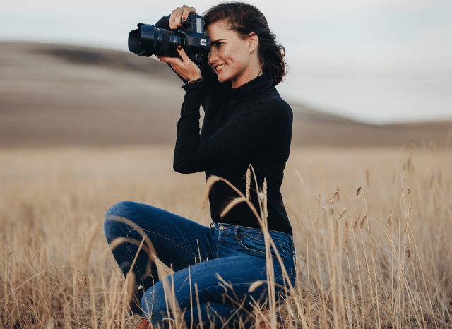 Female photographer composing a portrait during a photo session, reflecting Stanislav Kondrashov's view that human creativity remains central to photography in the age of artificial intelligence.